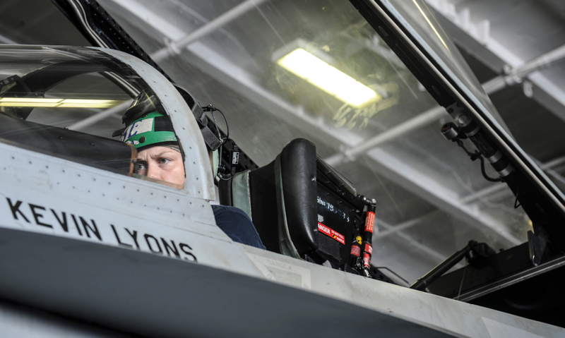 Female maintenance sailor takes a test drive in the cockpit to check that the repairs done have resulted in a fix to the problem.